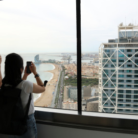 Dos visitants fotografien l'hotel Arts des de la torre Mapfre en el 48H Open House en una imatge d'arxiu