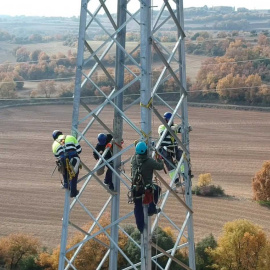 Operarios trabajando en una torre de alta tensión.