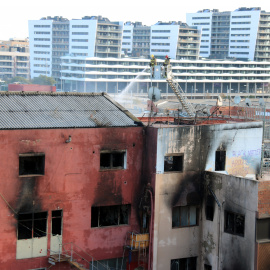 L'edifici on s'ha produït l'incendi de Badalona, amb bombers treballant.