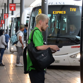 Un noi agafant la targeta abans d'entrar al bus