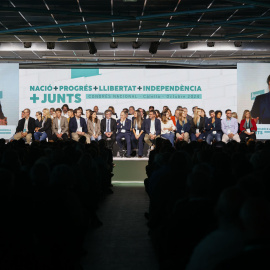 El secretario general de Junts, Jordi Turull, escucha la intervención de Carles Puigdemont (en las pantallas) durante el Congreso del partido que se celebró en Calella (Barcelona).