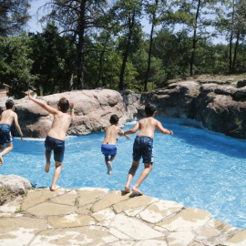 Pla general dels nens tirant-se a la piscina de la casa de colònies. Imatge del 25 de juny del 2020.