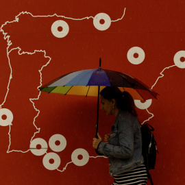 Una mujer se resguarda de la lluvia bajo un paraguas en Málaga.