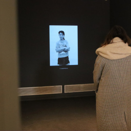 Una dona observa una de les fotografies d'una reclusa que es va projectar a la mostra 'Dones Invisibles' al Palau Robert de Barcelona.