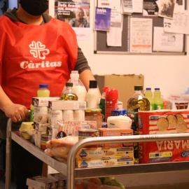 Un carro ple menjar a un punt de distribució d'aliments de Cáritas a Les Corts.