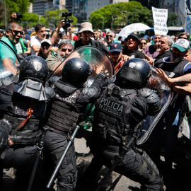 Un grupo de personas se enfrenta a la policía durante una marcha de miembros de la Asociación Trabajadores del Estado (ATE) en Buenos Aires (Argentina).