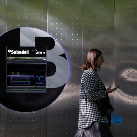 Una mujer pasa por delante de un cajero automático del Banco Sabadell en la Gran Via de Bilbao. REUTERS/Vincent West