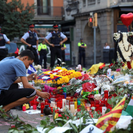 Un hombre enciende una vela en el memorial instalado en Las Ramblas, en memoria de las víctimas del atentado del pasado jueves. REUTERS/Susana Vera