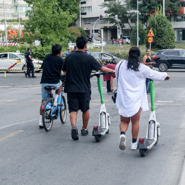 Fotografía de archivo de dos personas circulando en patinete eléctrico por Madrid.