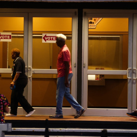 Los trabajadores electorales cuelgan carteles que dicen "votar" en las puertas antes de que se abran las urnas el día de las elecciones en el Coliseo de San Petersburgo, a 5 de noviembre de 2024.