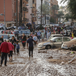 Varias personas caminan por una de las calles afectadas en Paiporta (València), tras las fuertes lluvias causadas por la DANA, a 30 de octubre de 2024.