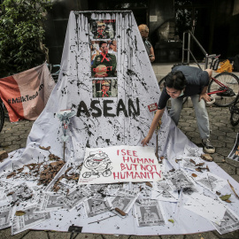 24/04/2021. Una mujer prepara una pancarta con retratos tachados de miembros de la junta militar en protesta contra el golpe de Estado en Myanmar. - Reuters