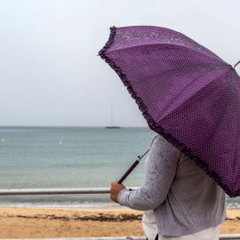 Una mujer se protege de la lluvia este viernes en Palma de Mallorca. EFE/Cati Cladera