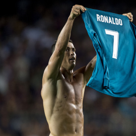 El jugador del Real Madrid Cristiano Ronaldo muestra su camiseta a los aficionados del Nou Camp, tras marcar el 1-2 de la ida de la Supercopa, lo que le valió la primera tarjeta amarilla. STRINGER / AFP