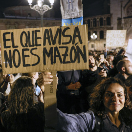 Una manifestante con una pancarta en la protesta por la gestión de la DANA, en València.