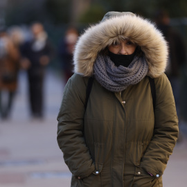 Una mujer pasea por Madrid cuando la capital se encuentra en aviso amarillo por temperaturas mínimas.