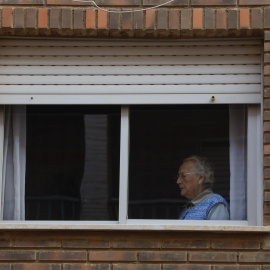 Una persona observa desde su casa las labores de limpieza en una calle en Catarroja, València, a 7 de noviembre de 2024.