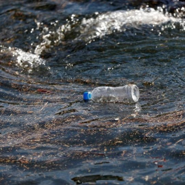 Una botella de plástico flota sobre las olas del mar.