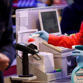 Una cajera desinfecta el datáfono en un supermercado. Foto: EFE/Archivo/Javier Etxezarreta