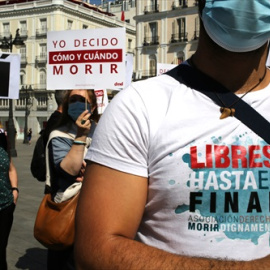 Un grupo de personas se reúne sosteniendo pancartas y carteles durante la concentración de la asociación Derecho a Morir Dignamente (DMD) en la Puerta del Sol, a 25 de junio de 2021, en Madrid, (España).