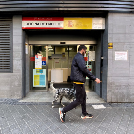 Un hombre pasa con su perro por la oficina de empleo de Acacias, a 4 de octubre de 2022, en Madrid (España).