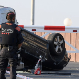 Un agente, junto al coche que usaron los terroristas en su ataque en Cambrils. - AFP