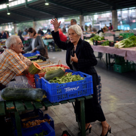 Una mujer hace la compra en un puesto de un mercado de Bilbao. REUTERS