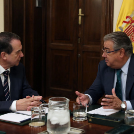 El ministro del Interior, Juan Ignacio Zoido (d), y el presidente de la Federación Española de Municipios y Provincias (FEMP), Abel Caballero (i), durante la reunión que han mantenido en la sede del Ministerio en Madrid, para estudiar vías de cooperac