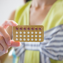 Una mano de mujer sosteniendo un panel de pastillas anticonceptivas (archivo)