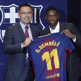 El nuevo fichaje del FC Barcelona, el francés Ousmane Dembélé (d), muestra hoy con el presidente del FC Barcelona, Josep Maria Bartomeu (i) la camiseta que llevará como jugador del equipo azulgrana. EFE/ Andreu Dalmau