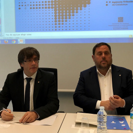 El president del Govern, Carles Puigdemont, y el vicepresidente, Oriol Junqueras, durante la rueda de prensa para presentar el despliegue de la Agencia Tributaria de Cataluña este lunes. EUROPA PRESS