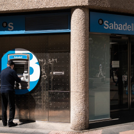 Un hombre opera el cajero automático de una oficina del Banco Sabadell en Madrid. E.P./Diego Radamés