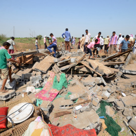 Un grupo de personas permanece de pie junto a una casa destruida por los ataques aéreos de la coalición árabe en Yemen. REUTERS/Abduljabbar Zeyad