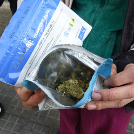 Un hombre muestra un sobre con marihuana comprada en una farmacia de Montevideo /AFP (MIGUEL ROJO)