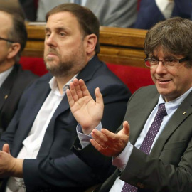 El presidente de la Generalitat, Carles Puigdemont, junto al vicepresidente del Govern, Oriol Junqueras,  durante el debate en el Parlament. - EFE