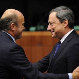 El ministro de Economía, Luis de Guindos, con el presidente del BCE, Mario Draghi, en una reunión del Eurogrupo en Bruselas. AFP