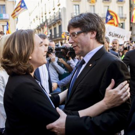 La alcaldesa de Barcelona, Ada Colau (i), saluda al presidente de la Generalitat, Carles Puigdemont (d), durante la concentración de alcaldes en la plaza Sant Jaume de Barcelona, convocada por la AMI y la ACM para protestar por las actuaciones de la Fisc