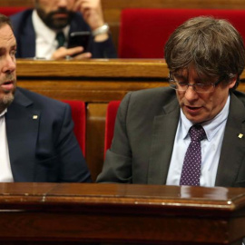 El presidente de la Generalitat, Carles Puigdemont (d) y el vicepresidente del Govern, Oriol Junqueras (i), abandonan hoy el hemiciclo del Parlament de Cataluña a los pocos minutos de iniciarse la sesión a causa de la petición del PPC de suspenderse pa