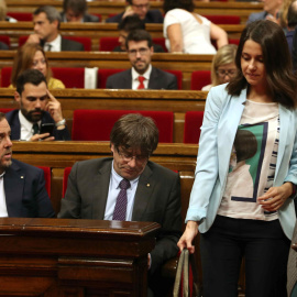 Las diputadas Inés Arrimadas, de Ciudadanos, y Andrea Levy, del PP, pasan junto a los escaños del president de la Generalitat, Carles Puigdemont, y del vicpresidente, Oriol Junqueras, en Parlament de Catalunya. EFE/Toni Albir