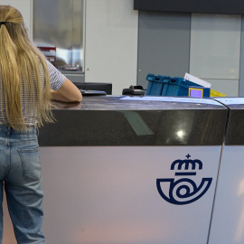 Una chica en el mostrador de la oficina de Correos de Cibeles, a 1 de junio de 2023, en Madrid.