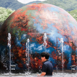 05/07/2023.- Un hombre camina frente a una instalación que muestra una Tierra en llamas en un parque en Daegu, Corea del Sur, a 5 de julio 2023.