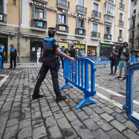 Una agente de policía coloca una valla en el arranque de los ‘No Sanfermines’, del 6 de julio de 2021, en Pamplona.