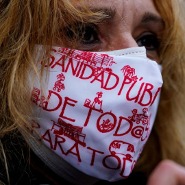 Una mujer con mascarilla, con lemas a favor de la sanidad pública, en una manifestación en Madrid.