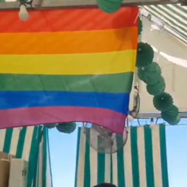 Bandera LGTBI en la caseta de Izquierda Unida en la Velá de Santa Ana, en Sevilla.