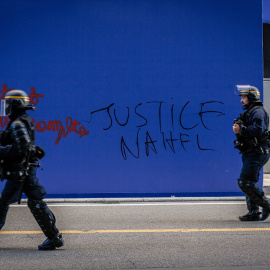 Policías antidisturbios frente a una pintada pidiendo "Justicia para Nahel" en París, Francia