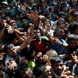 Los refugiados rohinya extienden su mano para alcanzar los suministros de socorro que les proporcionan las autoridades locales de Bangladesh, en el campamento improvisado de Cox. REUTERS / Mohammad Ponir Hossain