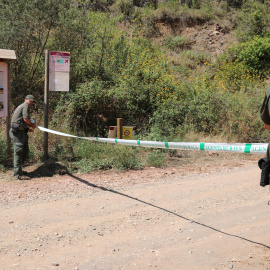 Dos Agents Rurals col·loquen una cinta per impedir l'accés al Parc Natural de la Serra de Montsant des de la Cartoixa d'Escaladei.