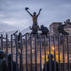 Inmigrantes subsaharianos encaramados a la valla de Melilla.- AFP