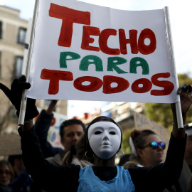 Un manifestante sujeta una pancarta donde se lee "TECHO PARA TODOS" en la protesta convocada por la plataforma "Nadie sin Hogar" por el derecho a la vivienda, en el centro de Madrid, España, 26 de noviembre de economía 2015. REUTERS / Paul Hanna