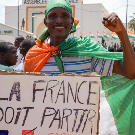 Un manifestante carga una pancarta que dice: "Los franceses deben partir"